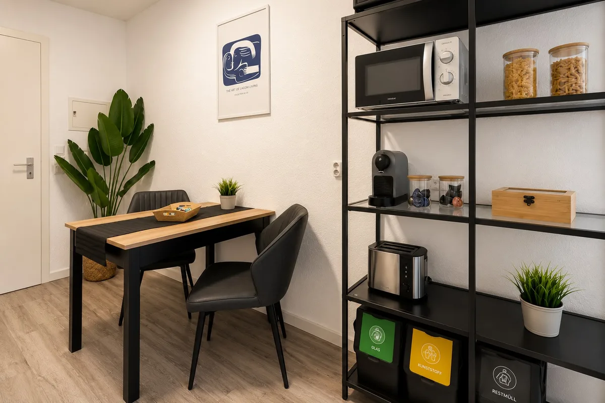 Esstisch für zwei Personen neben einem Regal mit Mikrowelle und Kaffeemaschine